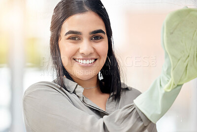 Buy stock photo Shot of a young woman washing windows at home