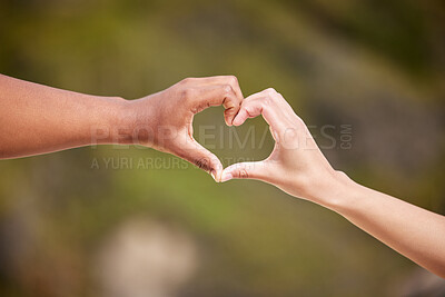 Buy stock photo Shot of two unrecognizable people making a heart gesture with their hands in nature
