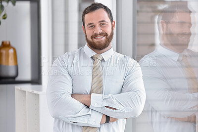 Buy stock photo Portrait of a confident young businessman standing at a window in an office