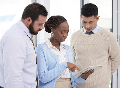 Buy stock photo Shot of a group of business people using a digital tablet during a meeting