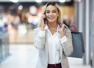 Buy stock photo Shot of a young woman using her smartphone to make a call while shopping