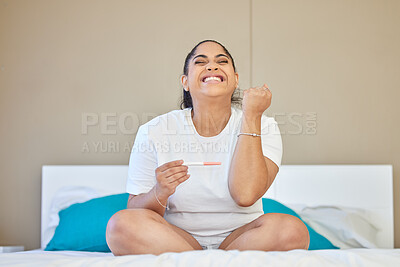 Buy stock photo Shot of a young woman cheering after taking a pregnancy test at home