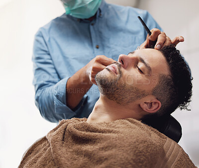 Buy stock photo Cropped shot of a handsome young man getting groomed by a barber