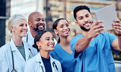 Buy stock photo Shot of a group of doctors taking a selfie in the city