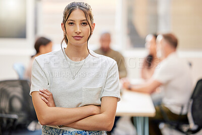 Buy stock photo Shot of a young businesswoman standing with her arms crossed in the boardroom with her colleagues in the background