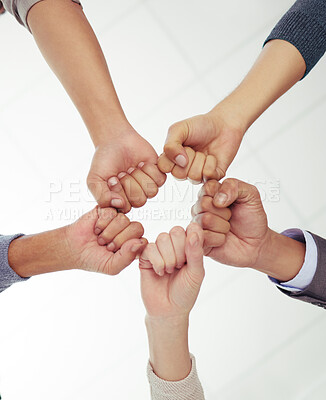 Buy stock photo Below shot of a group of unrecognizable businesspeople fist bumping against a white background