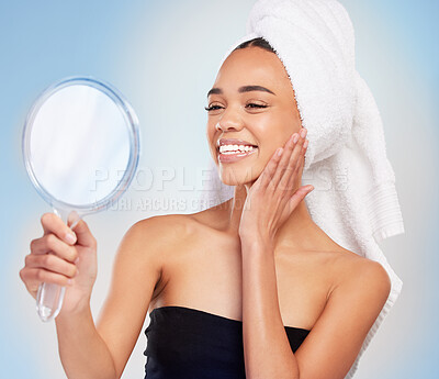 Buy stock photo Shot of a young woman looking in a mirror against a blue background
