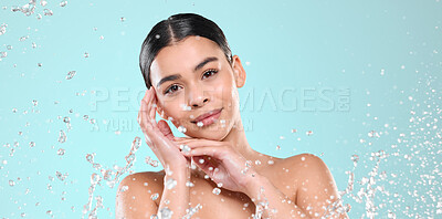 Buy stock photo Shot of a beautiful young woman being splashed with water against a studio background