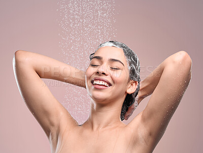 Buy stock photo Shot of a young woman washing her hair against a studio background