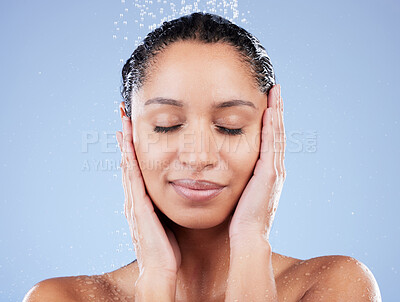 Buy stock photo Shot of a young woman taking a shower against a blue background