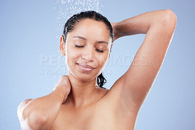 Buy stock photo Shot of a young woman taking a shower against a blue background