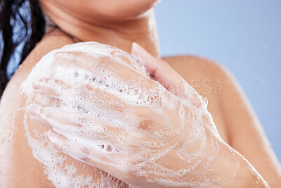 Buy stock photo Shot of an unrecognizable woman taking a shower against a blue background