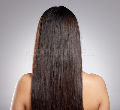 Buy stock photo Rearview shot of a young woman with long silky hair against a grey background
