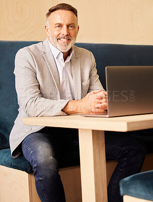Buy stock photo Cropped portrait of a handsome mature businessman working on his laptop at a desk in the office