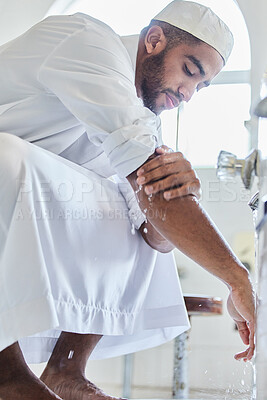 Buy stock photo Shot of a young man washing his hand in a mosque