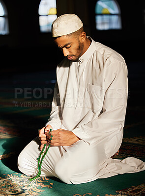 Buy stock photo Shot of a young muslim male praying in a mosque