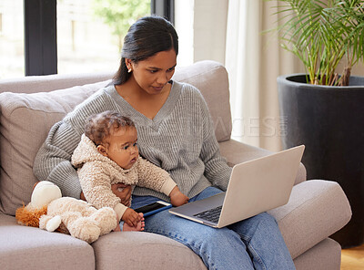 Buy stock photo Shot of a young woman working on her laptop while sitting in the lounge with her baby