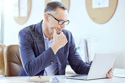 Buy stock photo Shot of a mature businessman using a laptop in an office at work