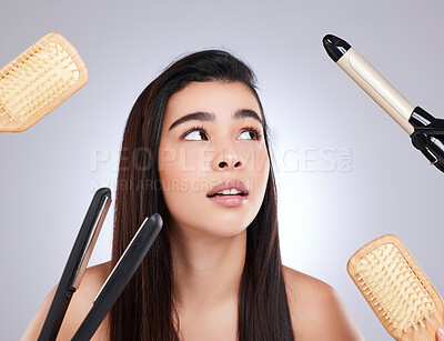 Buy stock photo Studio shot of an attractive young woman surrounded by haircare products against a grey background