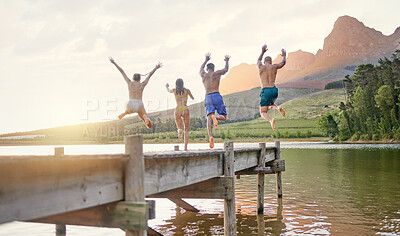Buy stock photo Shot of a group of friends having fun at a lake