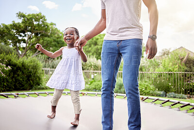Buy stock photo Shot of a little girl jumping on a trampoline with her father outdoors