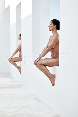 Buy stock photo Two beautiful mixed race women posing nude while sitting on window ledges outside. Sexy hot naked hispanic models covering their boobs with their arms. Nudists feeling sensual, seductive and free