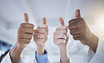 Closeup of diverse group of unknown healthcare professionals using hand gestures to show a thumbs up in the clinic. Medical staff and doctors with sign of approval and symbol of trust in a hospital
