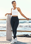 Full length of a fit young hispanic woman in sportswear taking a break from her early morning run along a promenade