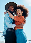 Portrait of two young diverse people embracing and smiling while wearing trendy and fashionable clothes outside. Mixed race african american couple enjoying a romantic date outside 