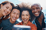 Diverse group of friends using cellphone to take selfies while bonding outside. African American woman with an afro smiling and taking pictures with her clique for social media. Millennials using tech