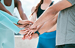 Closeup of diverse group of sporty people stacking hands together in pile to express unity, support and trust. Motivated athletes huddled in circle to celebrate winning achievement. Joining for collaboration and team spirit during training workout