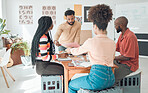 Group of diverse businesspeople having a meeting in a modern office at work. Young hispanic businessman looking at an idea on paper in a boardroom with colleagues. Businesspeople planning together