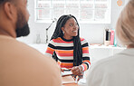 Group of diverse businesspeople having a meeting in a modern office at work. Young happy african american businesswoman sitting in a boardroom with colleagues. Creative businesspeople planning together