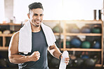 Happy trainer cheering in the gym. Fit, strong man taking a break from his workout. Bodybuilder using a towel after his exercise routine. Sporty athlete enjoying his workout routine.
