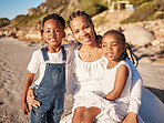 Portrait of a happy loving young african american mother at the beach with her two children. Little girl and boy enjoying vacation by the sea with their mom