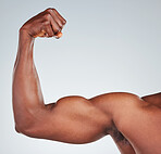 Closeup of one unrecognizable African American fitness model posing topless in and looking muscular. Confident black male athlete isolated on grey copyspace in a studio flexing his bicep