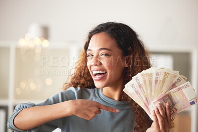 Buy stock photo One happy young mixed race woman feeling excited and using hand gesture to point at money. Hispanic woman holding euro cash and showing wealth. Budget finances, invest and saving for financial freedom