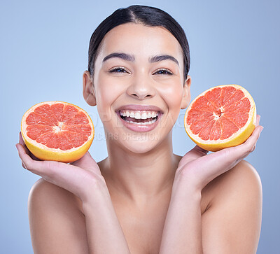 Buy stock photo Portrait of a happy mixed race woman holding a grapefruit. Hispanic model promoting the skin benefits of citrus against a blue copyspace background