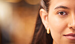 Closeup portrait of a beautiful young woman with smooth flawless skin. Indian female showing off her natural beauty and clear complexion while posing with a nose piercing. 