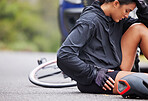 Beautiful, athletic, mixed race young woman suffering with injury while exercising outside. Healthy and sporty female athlete experiencing muscle cramps while  doing a cardio workout outside in nature