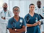 Group of diverse serious doctors standing with their arms crossed while working at a hospital. Expert medical professionals looking focused at work together at a clinic