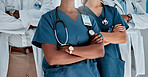 Group of doctors standing with their arms crossed while working at a hospital. Expert medical professionals standing at work together at a clinic