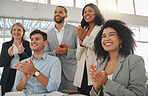 Group of businesspeople in a meeting together at work. Young joyful hispanic businesswoman with a curly afro clapping with her colleagues while in a workshop. Business professionals clapping in support in an office