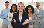 Group of diverse and powerful businesspeople standing together with their arms crossed in an office. Confident and mature manager leading her team of professionals in the workplace