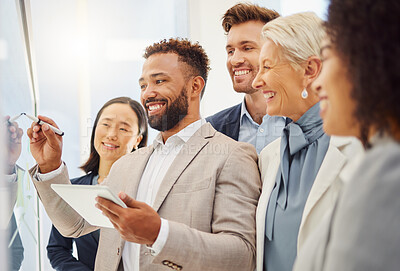 Buy stock photo Young mixed race businessman using a digital tablet while leading his diverse team by explaining project plans and analysing notes on a glass wall in an office. Group of smiling businesspeople brainstorming ideas and strategies together