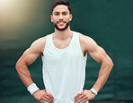 Portrait of smiling mixed race tennis player standing alone on a court. Fit hispanic sports professional with hands on hips and feeling confident in sports club. Ready for an athletic and healthy game