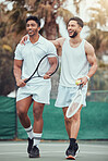 Full length two ethnic tennis players holding rackets and bonding playing court game. Smiling athletes team together after match. Play competitive doubles match for fitness and health in sports club
