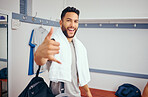Cheerful man making a hand gesture in his gym locker room. Portrait of a mixed race man taking a break from his match to relax in his gym locker room. Happy athlete relaxing after a squash match