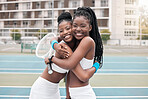 Happy friends hugging after a game of tennis. Cheerful tennis players being affectionate. Professional tennis players embracing after a match. Fit friends bonding on the tennis court