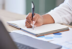 Businessperson writing in a notebook working in an office at work. Closeup of a business professional holding a pen and taking notes in a diary. Person writing ideas in a book